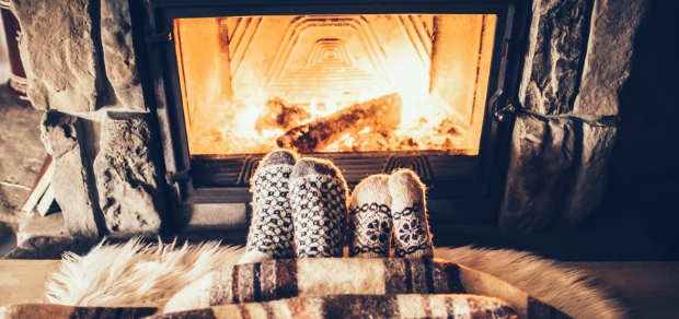 couple wearing socks by a fireplace