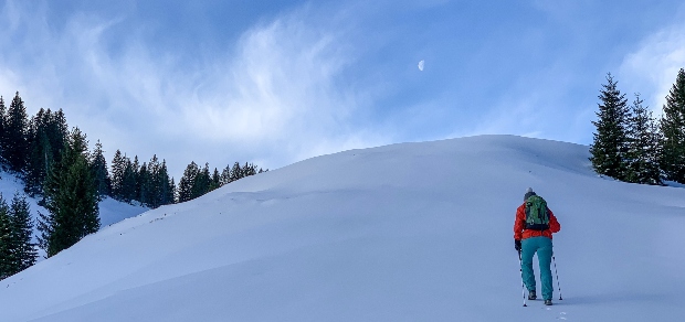 man hiking up a snowy hill