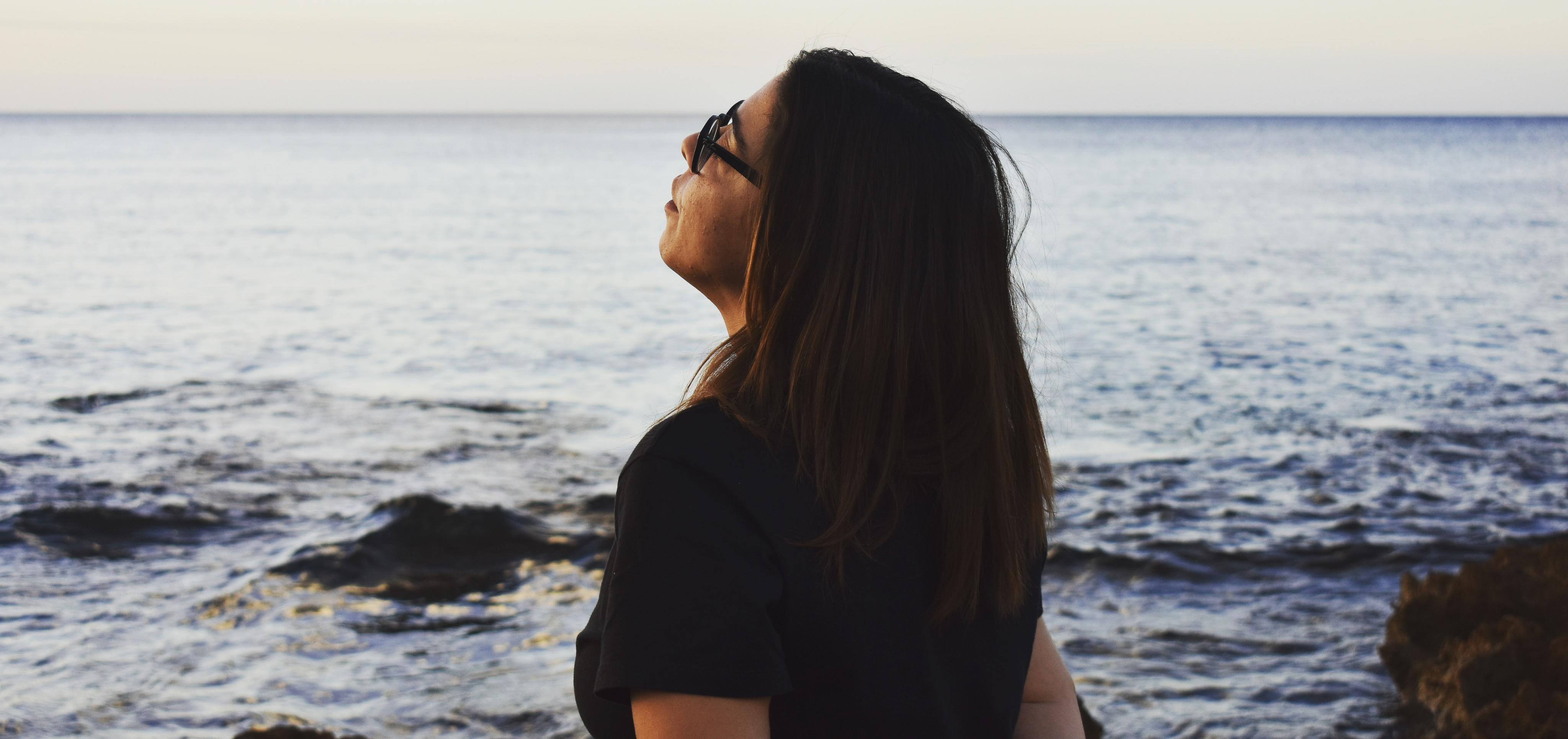 woman wearing eyeglasses standing by the water