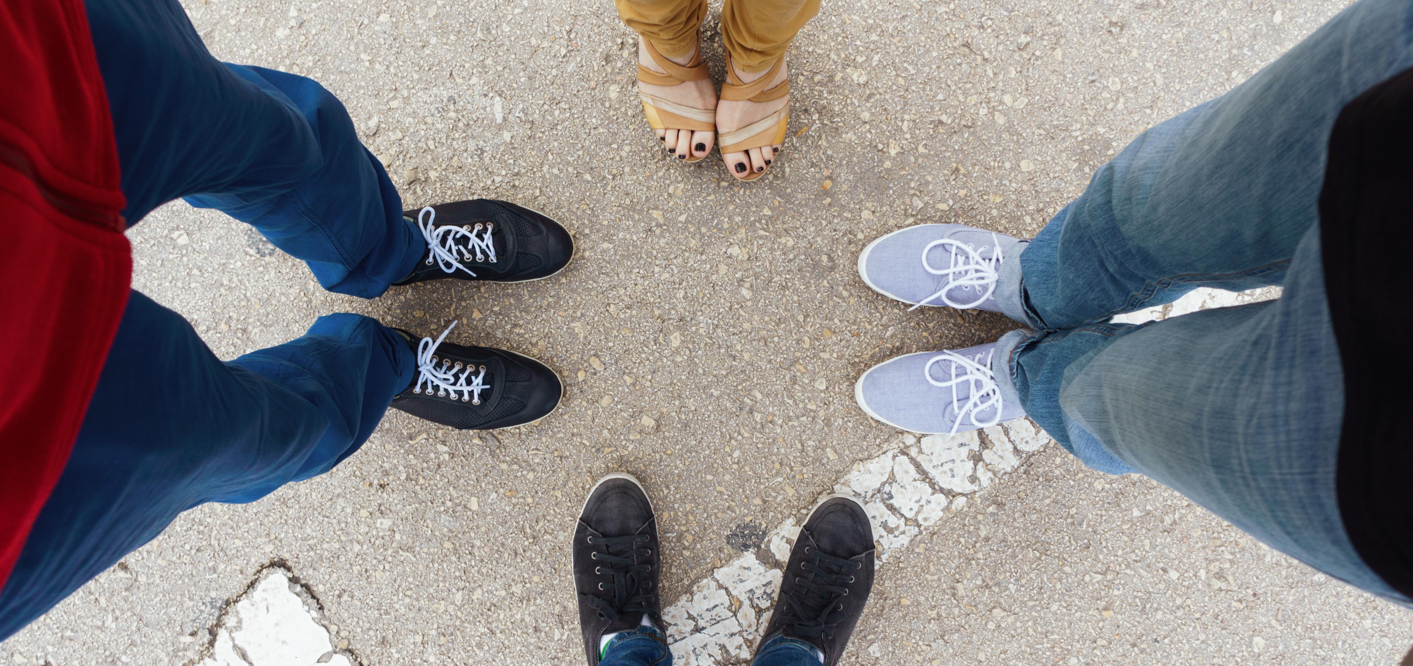 four people standing in a circle