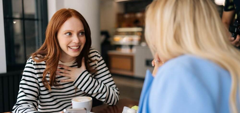 two women having a conversation in a cafe