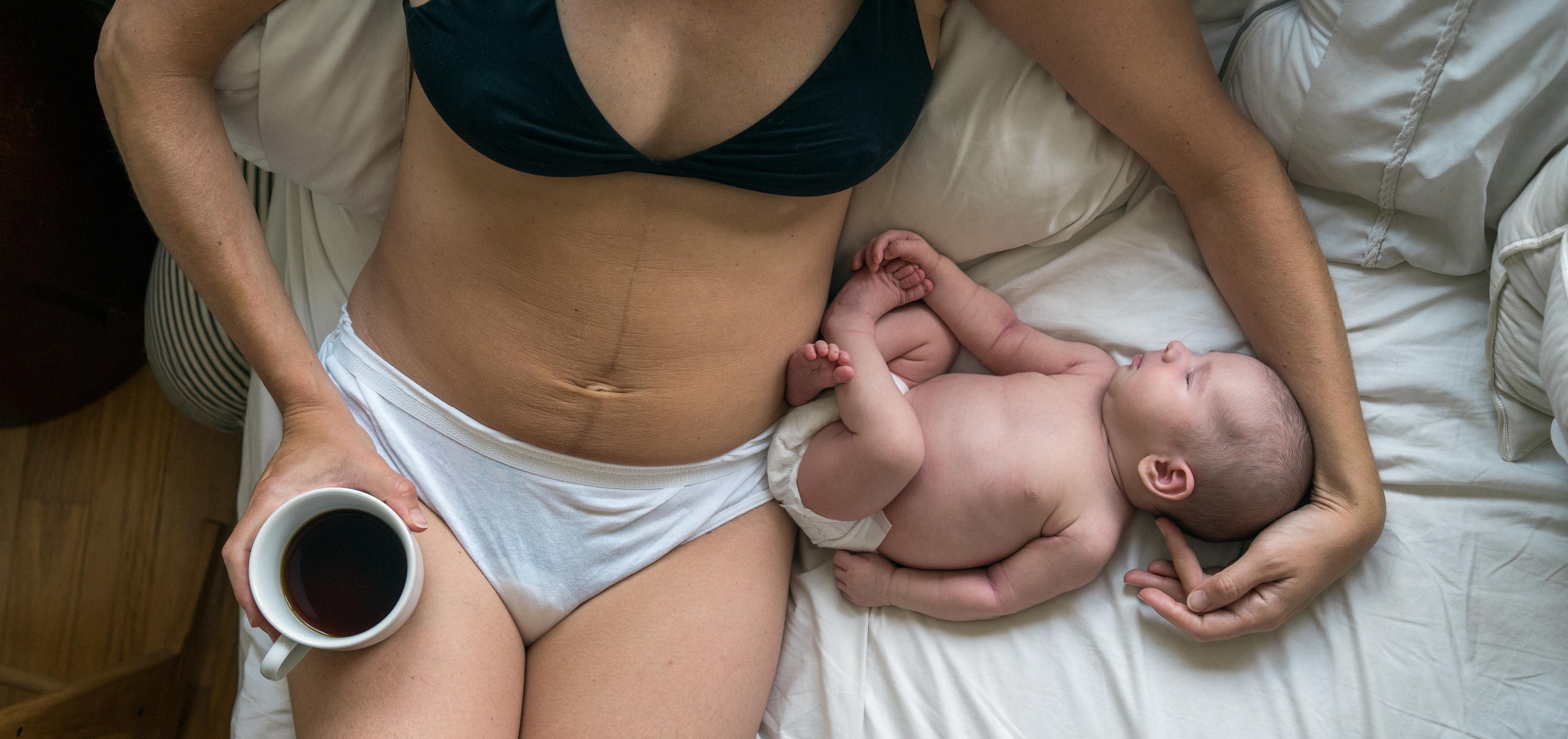 mother cradling her baby in bed