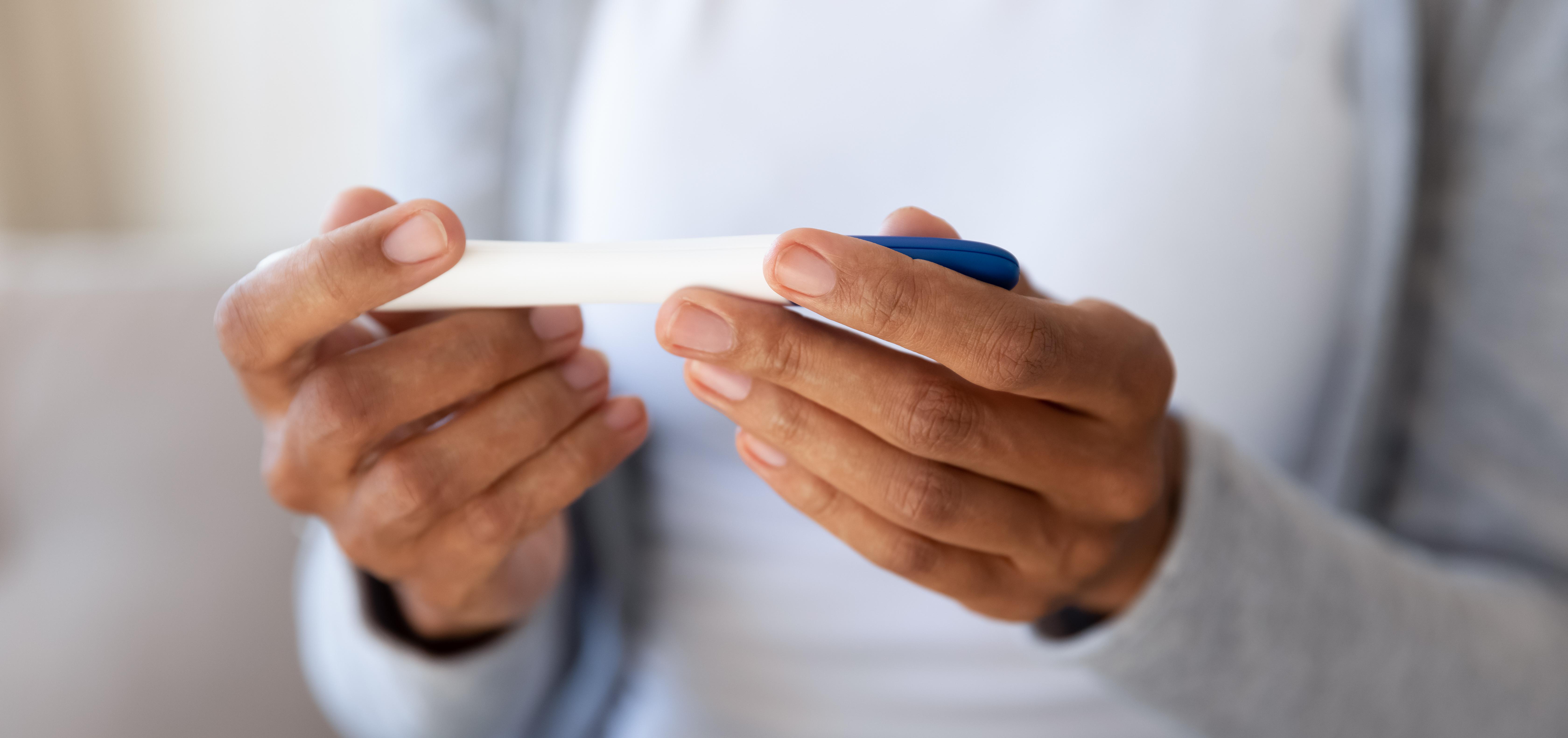 woman holding a home pregnancy test in her hands