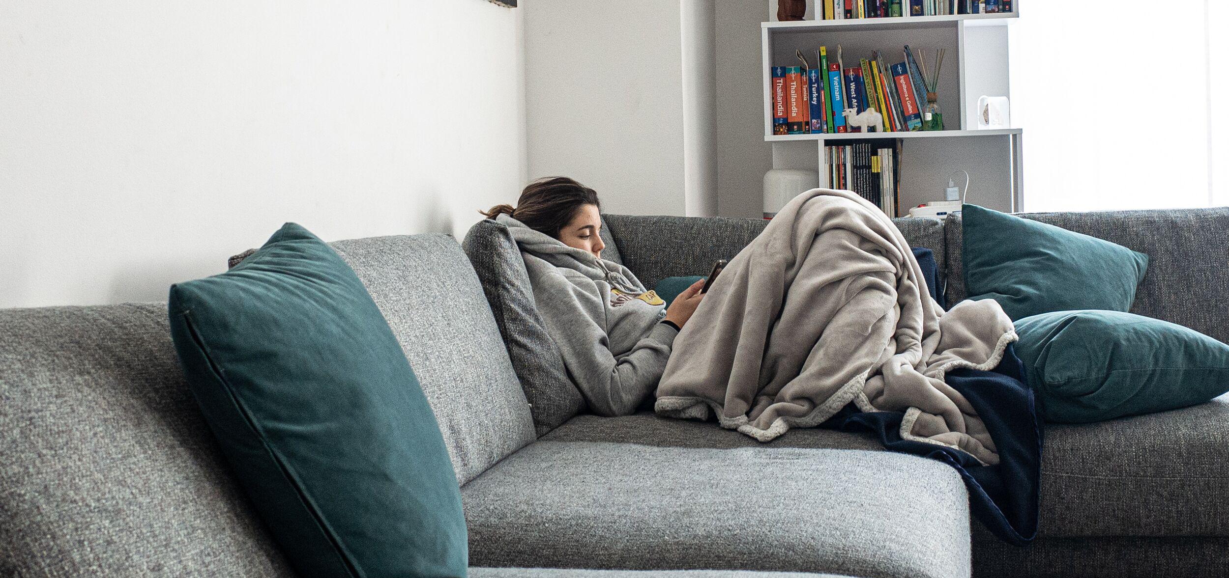 pregnant woman feeling fatigued, sitting on her couch