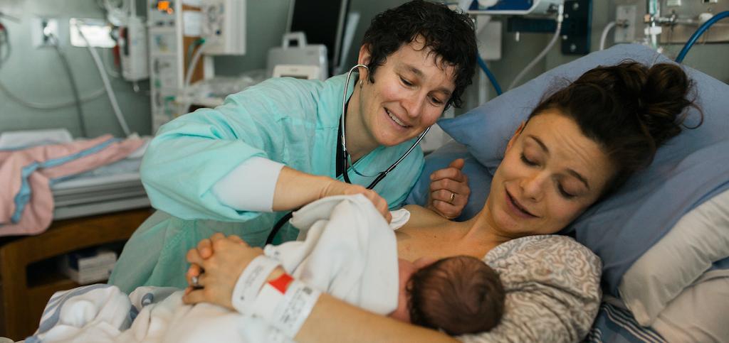 Nurse overseeing a woman with a baby. 