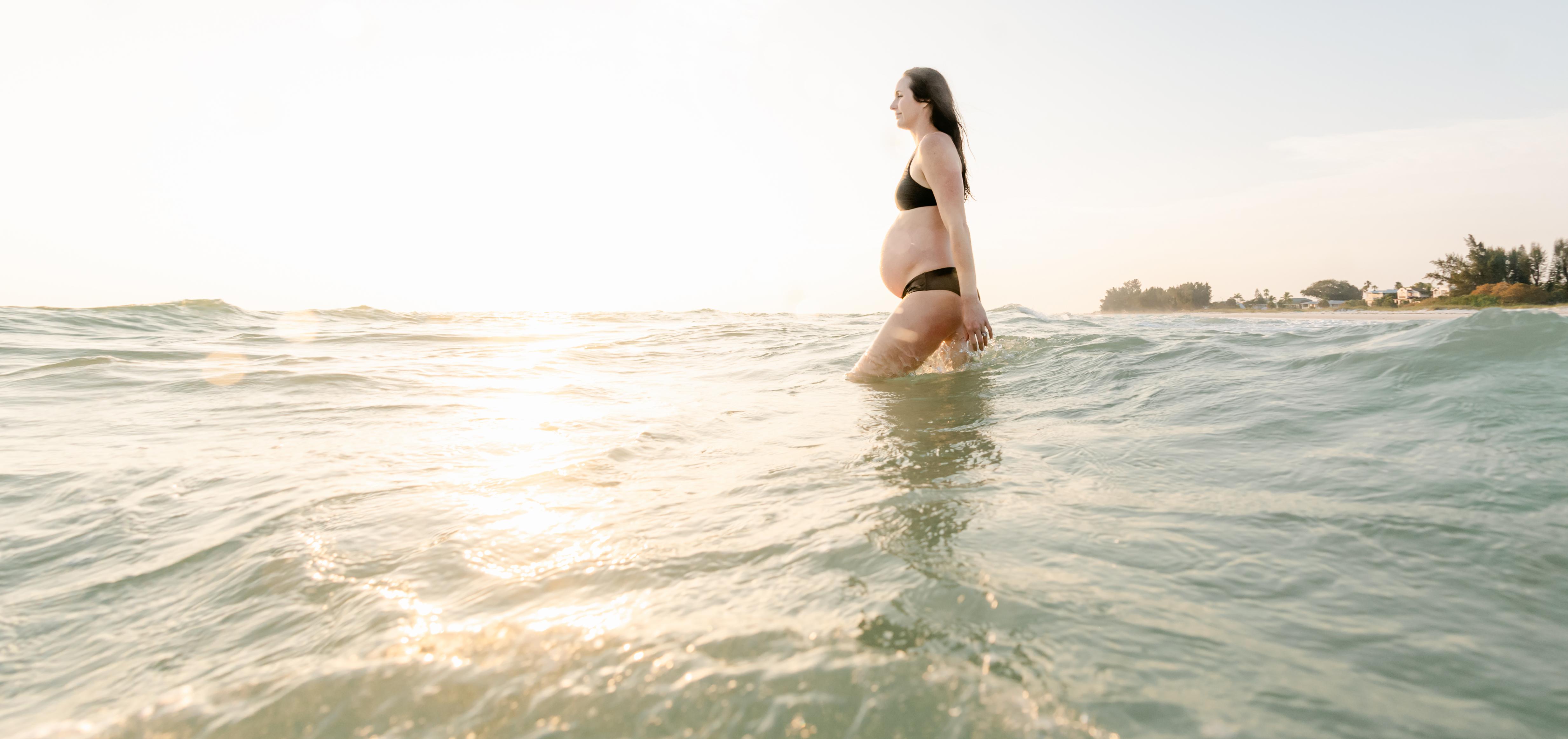 pregnant woman wading in the ocean