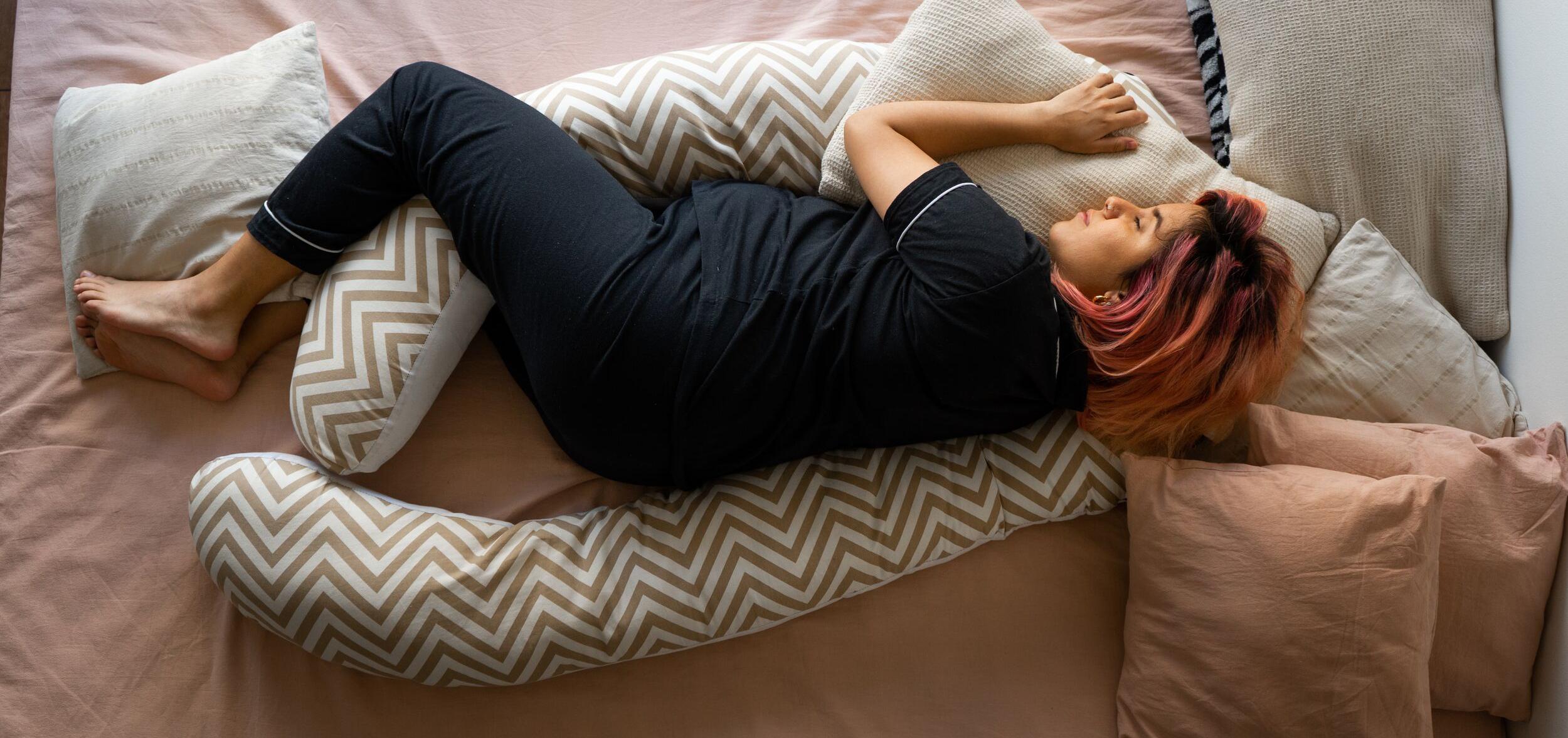 Pregnant woman in bed with pillows surrounding her