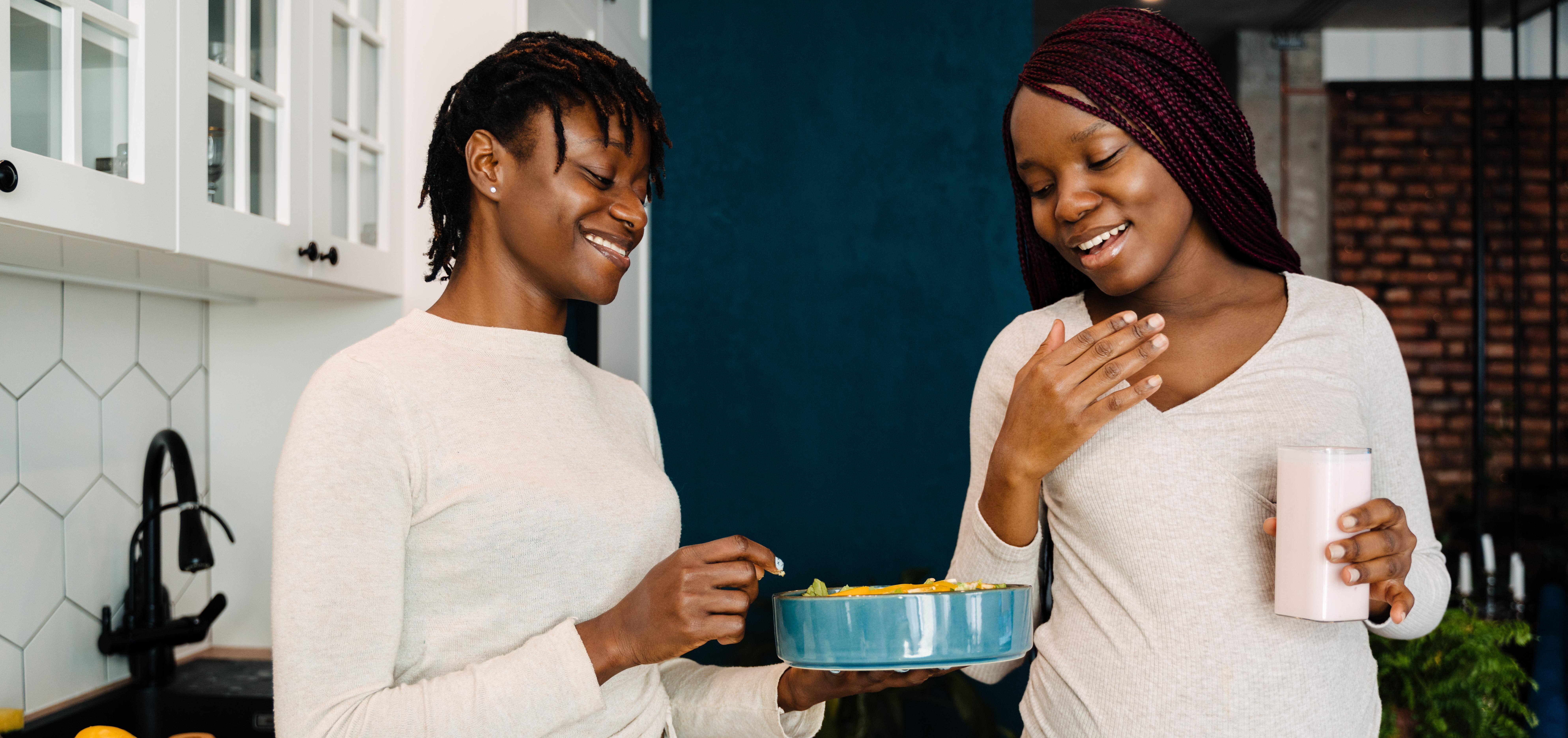 Food to Avoid During Pregnancy. A pregnant woman and her partner in the kitchen having a snack.