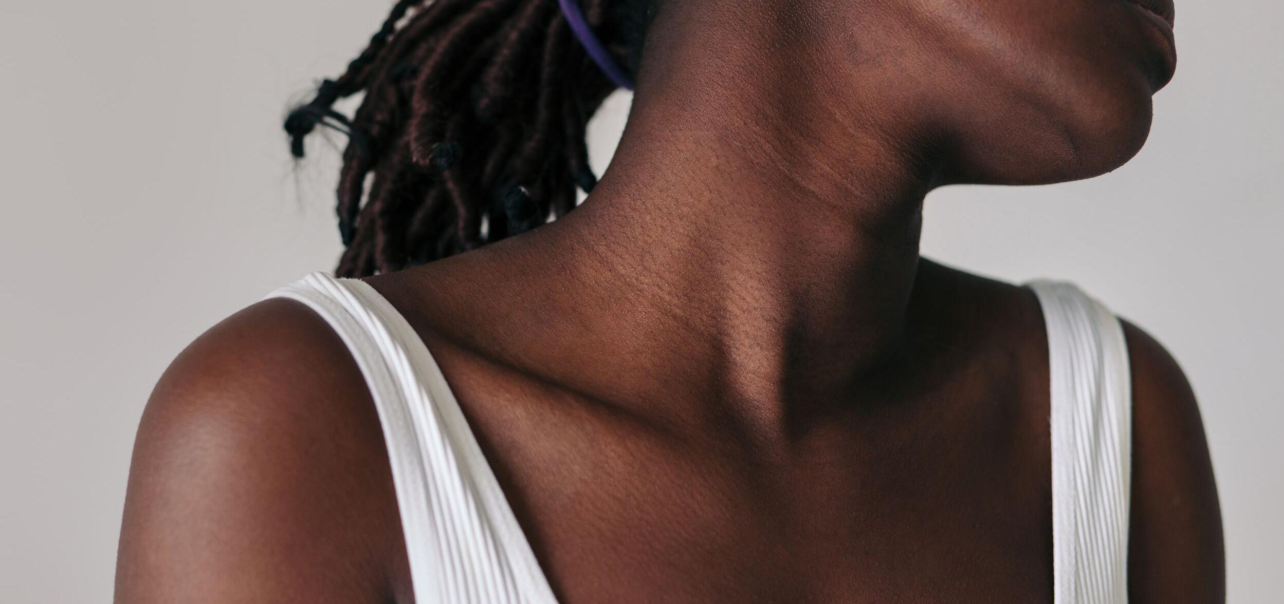 Black woman in a tank top looking away from camera